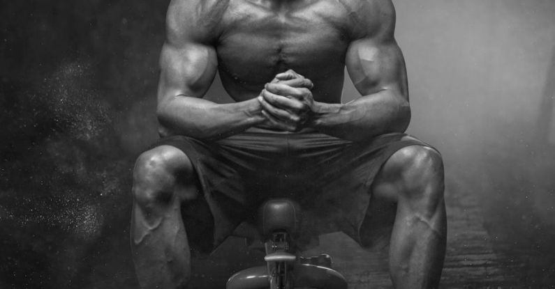 Fitness - Grayscale Photo of Man Sitting on Bench