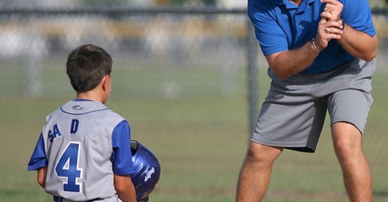 Coaching - Man Kneeling on Baseball Field Beside Man
