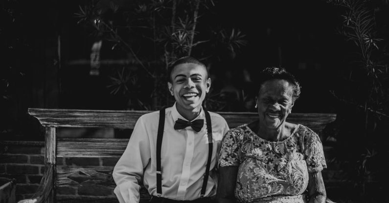 Age - Man and Woman Sitting on Bench in Grayscale Photography