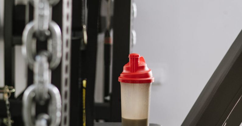 Protein Shakes - A Bottle with a Protein Shake Standing on a Machine at the Gym