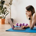 Tracker - Young sportive woman using laptop on floor