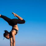 Yoga - Woman With Arms Outstretched Against Blue Sky