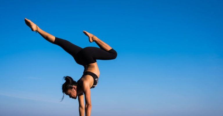 Yoga - Woman With Arms Outstretched Against Blue Sky